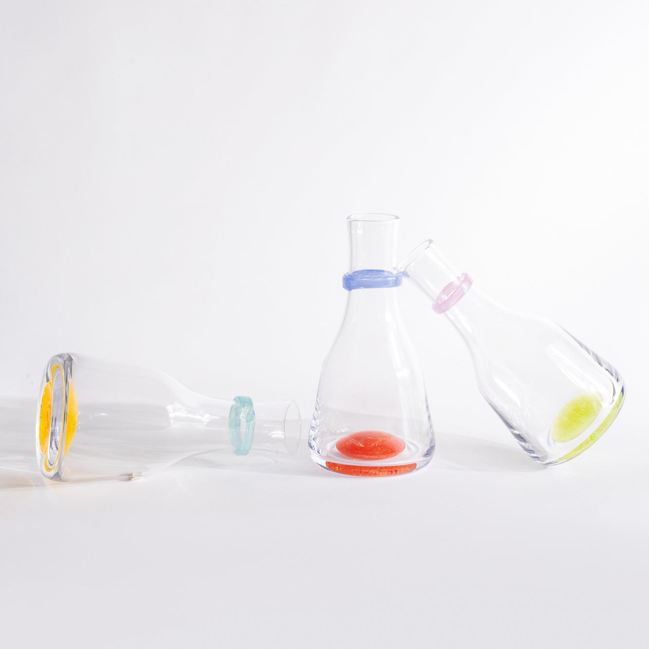 Three glass bottles with colorful labels on a white background
